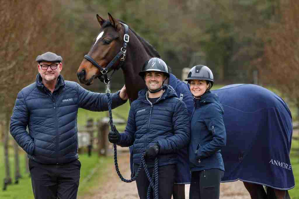 The three directors of Anmore Dressage standing beside a dressage horse at the yard